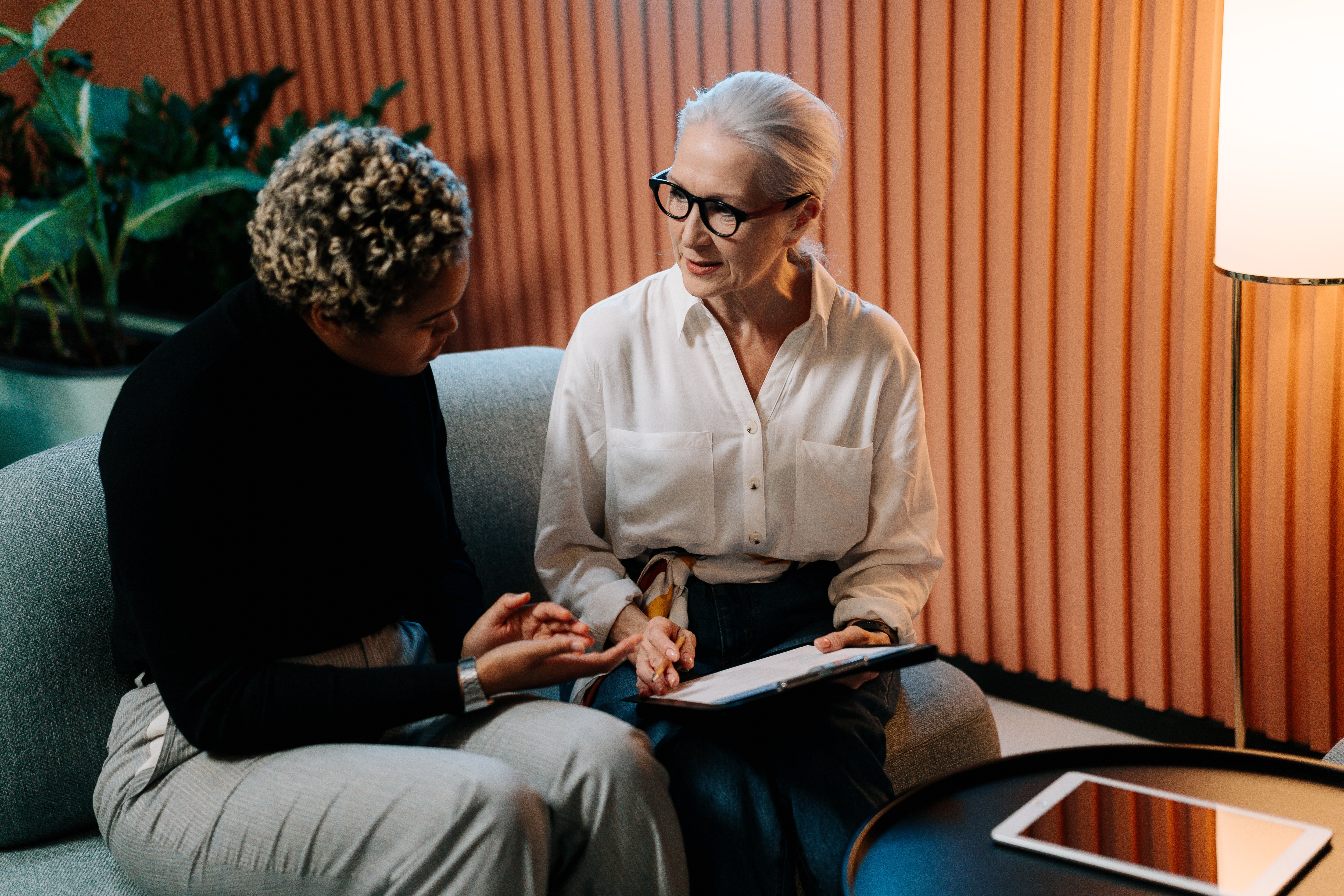 Two woman sitting down in an an office having a conversation